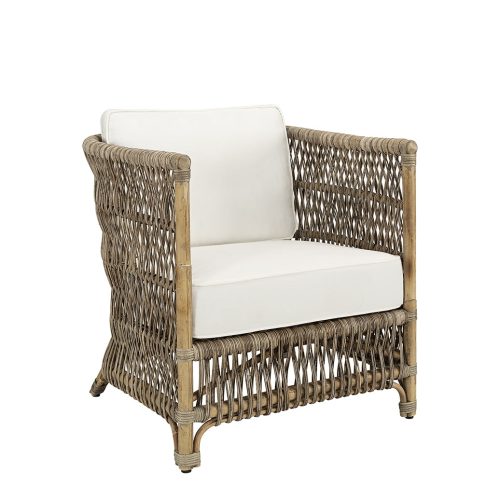 Artwood Rottingfåtölj Mauro i naturfärgad rotting med mjuk sittdyna, ergonomisk design med höga armstöd, placerad i ett stilrent inomhusrum.